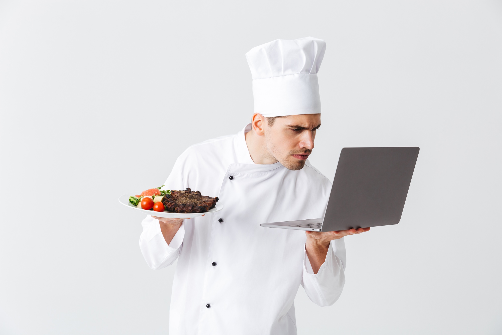Chef teaching online with laptop and plated dish